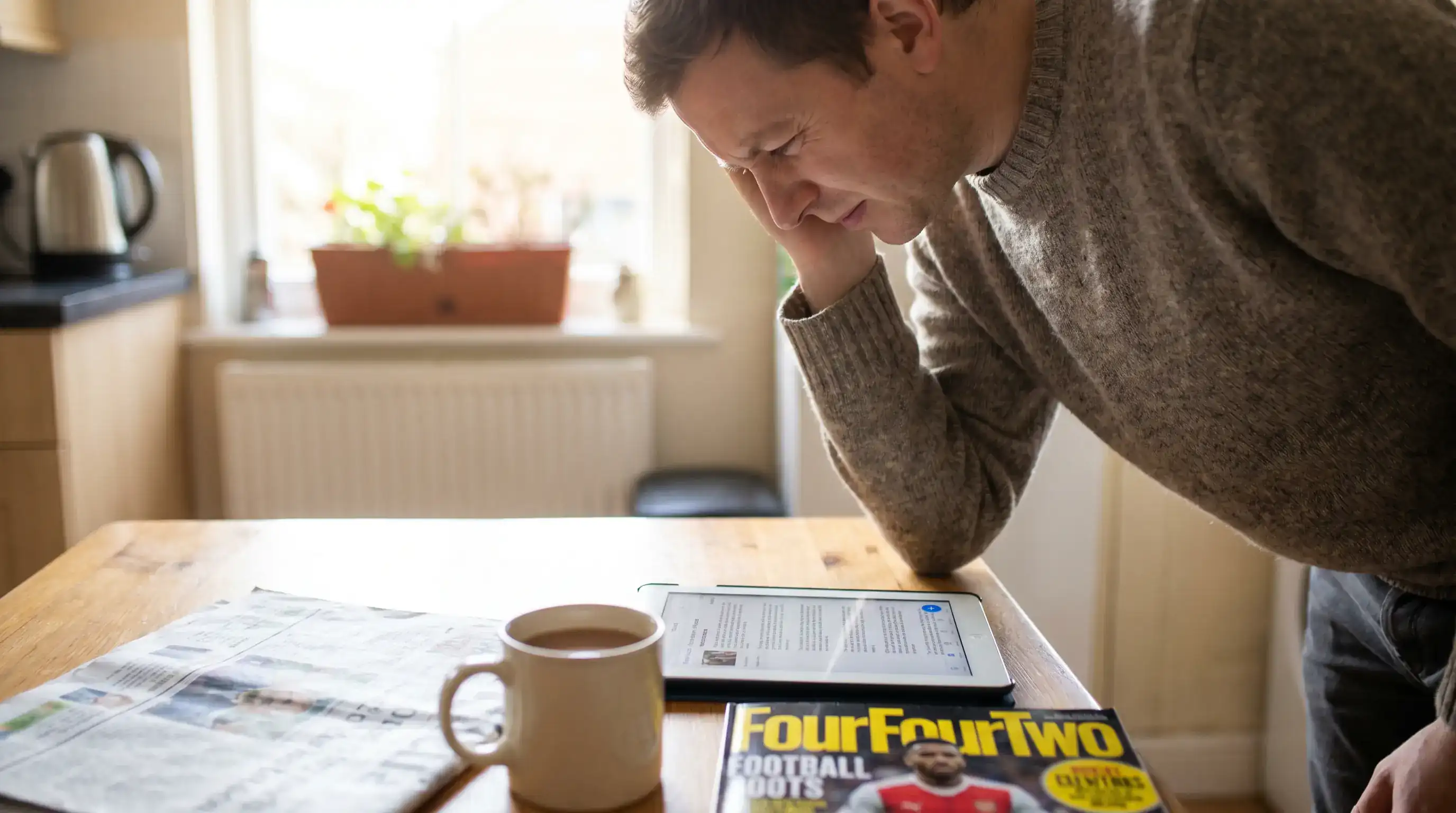 Football fan reviewing accumulator insurance terms on a tablet at home