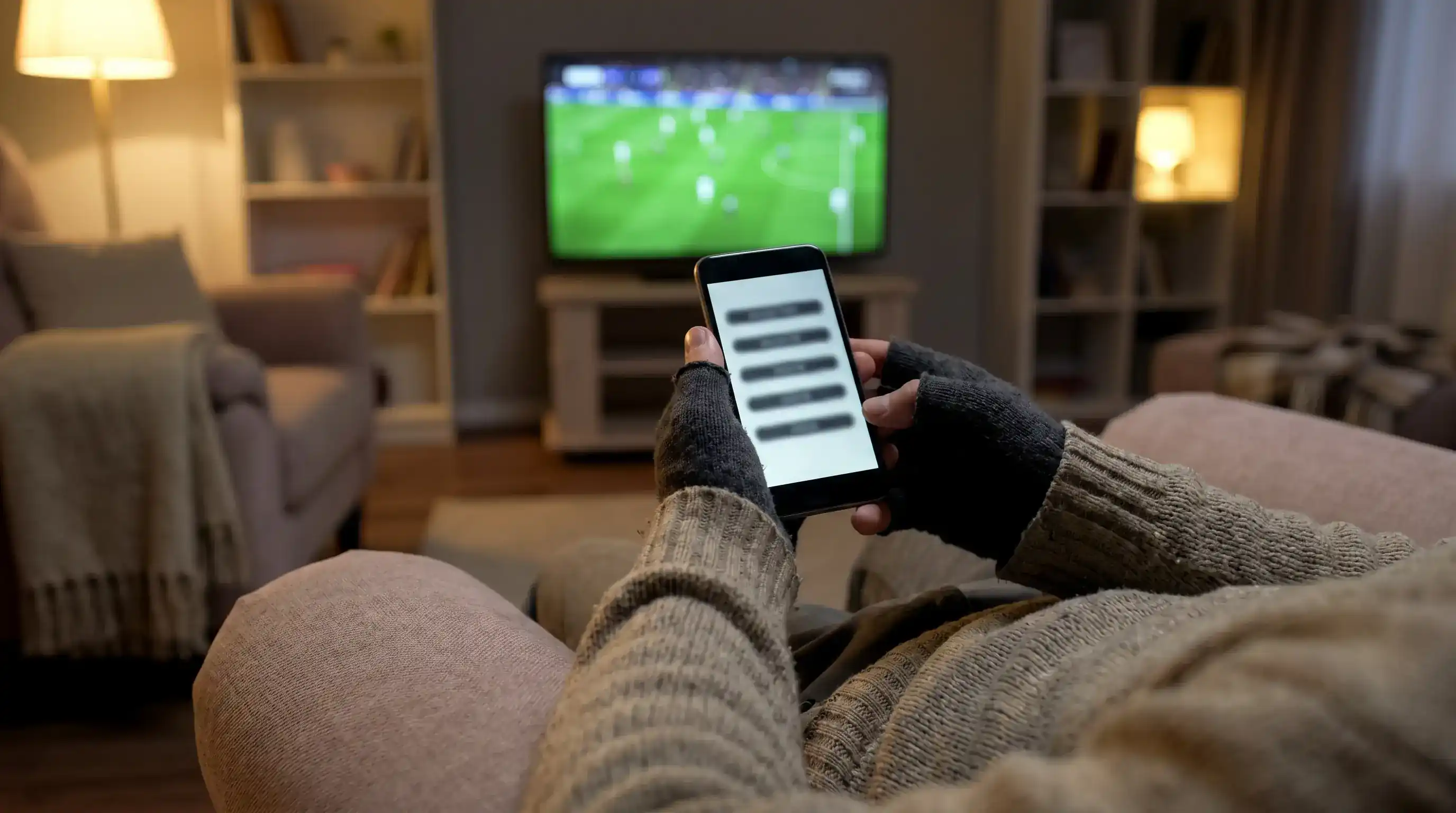 Football fan reviewing an accumulator bet slip on a phone